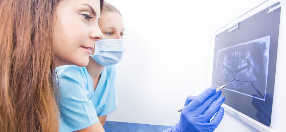 Dentist pointing out a root canal to a patient on an x-ray.